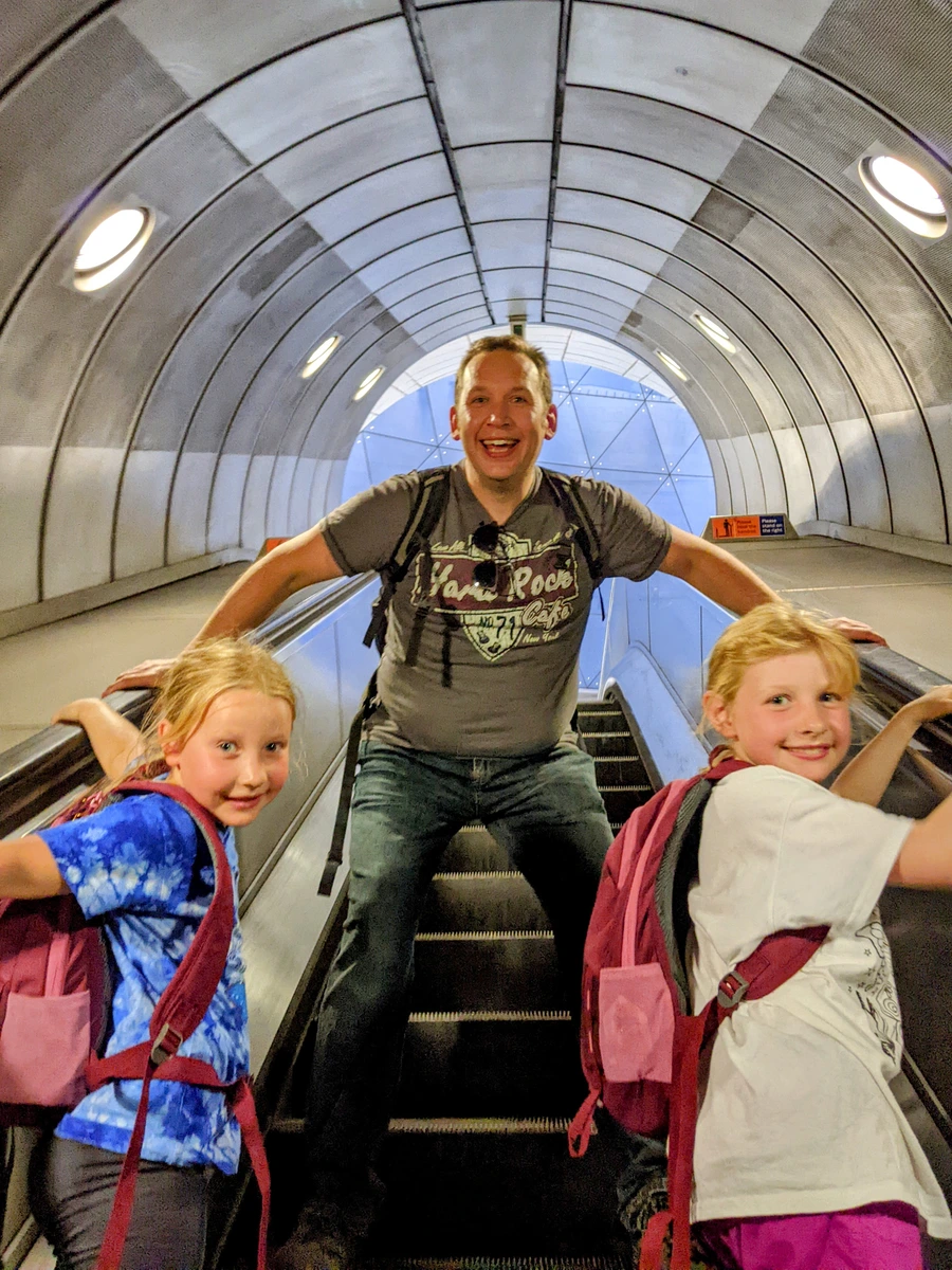 Adrian, Eva and Georgia looking excited as they ride the escalator into the tube. 