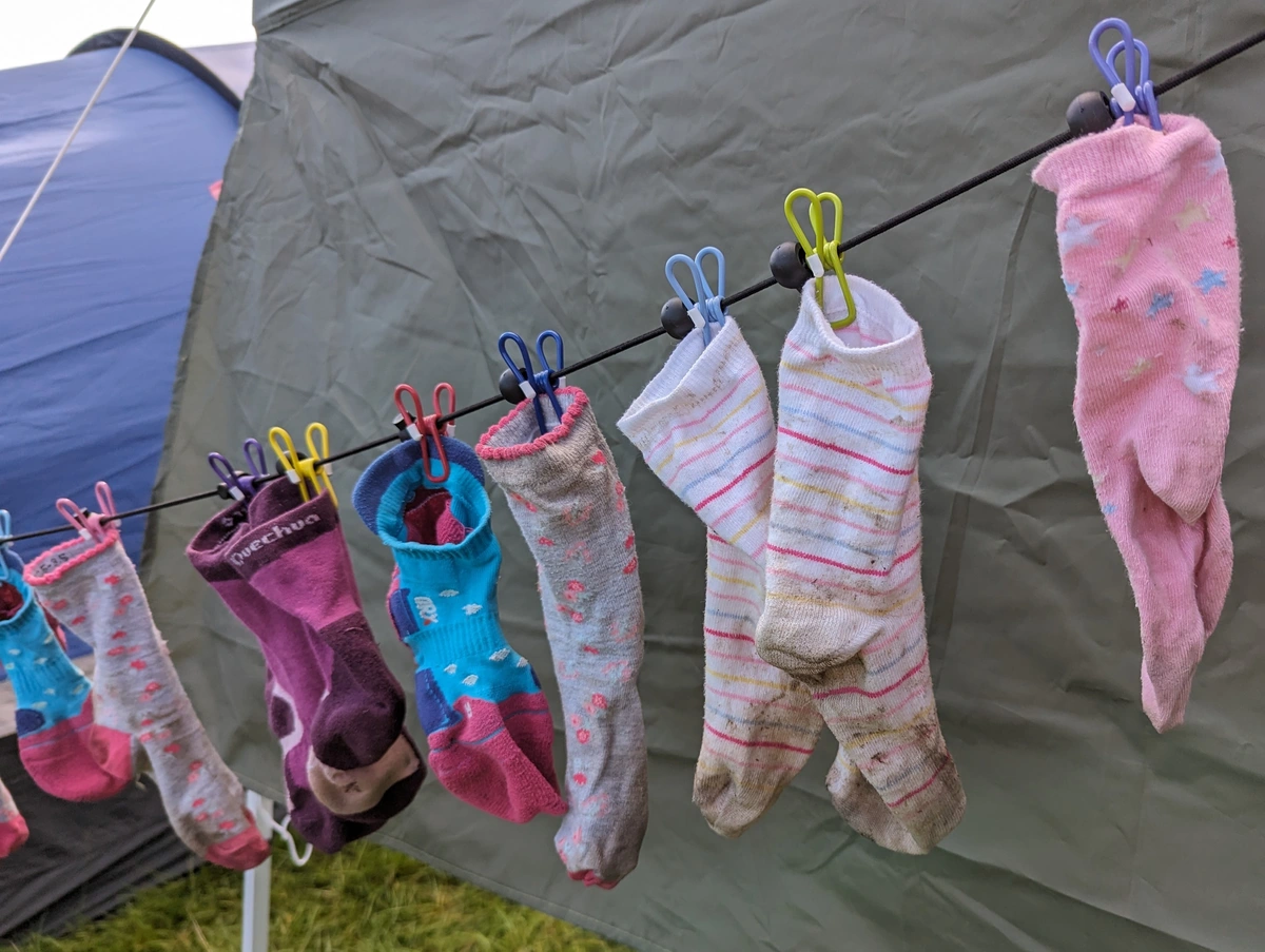 Muddy socks hung on a washine line on a camping trip.