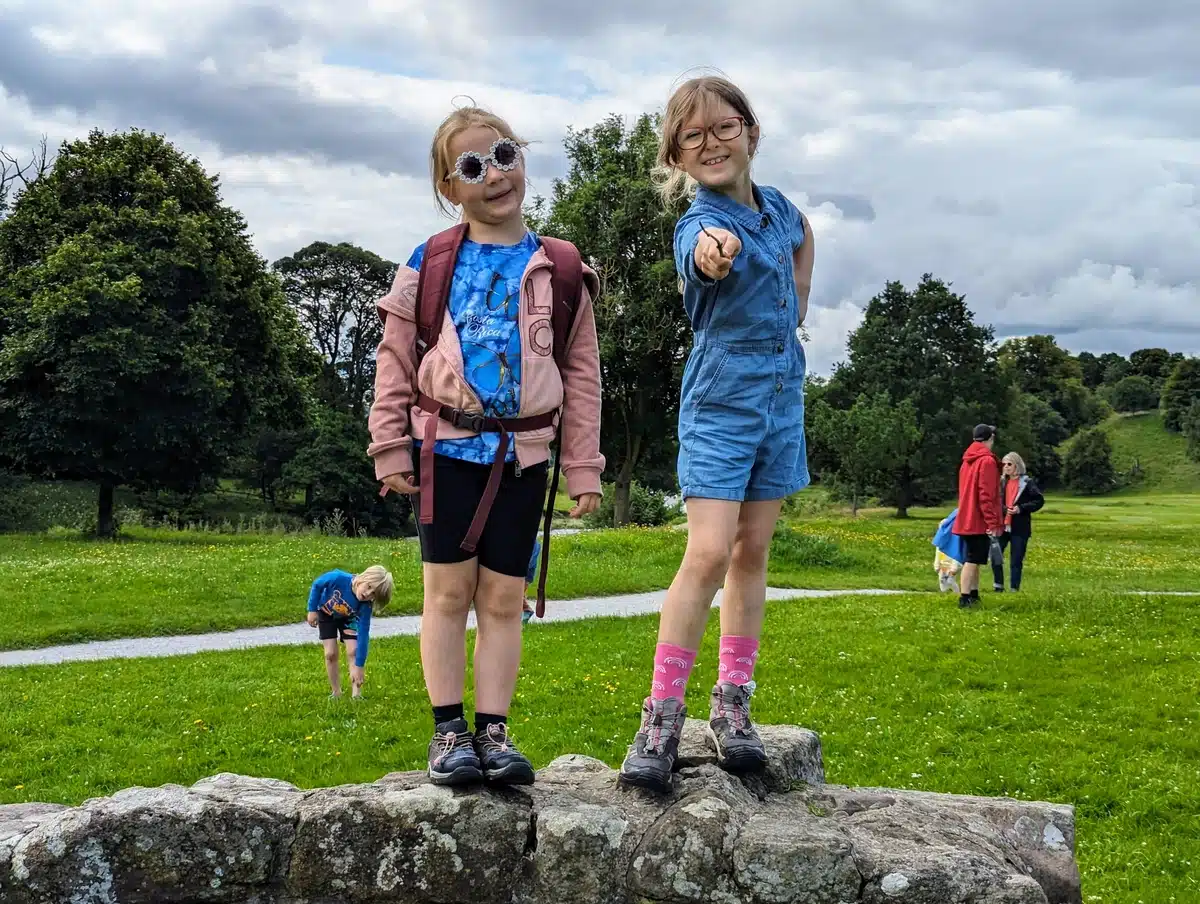 Two young children stand on a rock near Boltin Abbey - A Family Guide to Bolton Abbey and Beyond