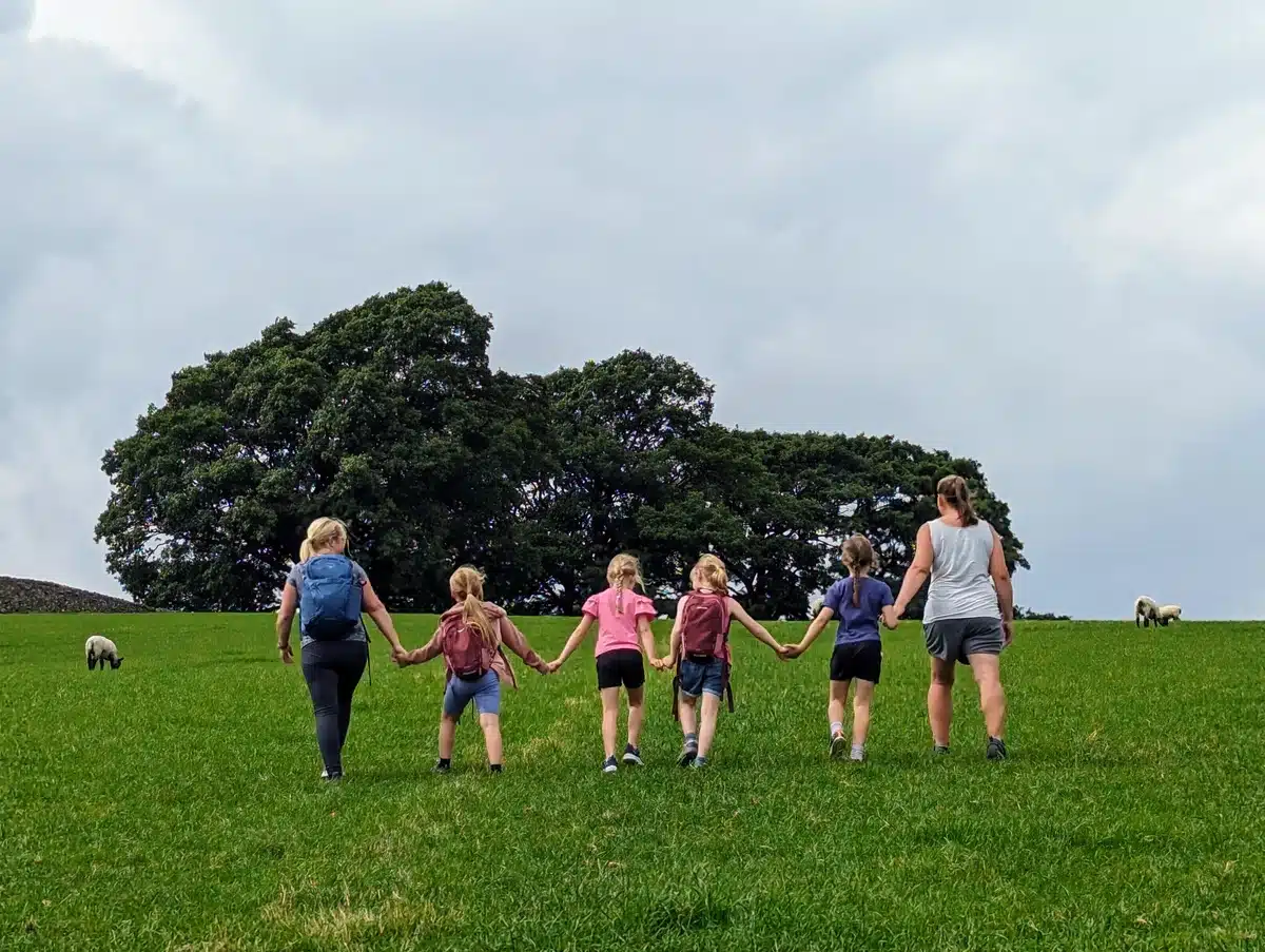 A group of children and parents hold hands as they walk up Barden Moor.
