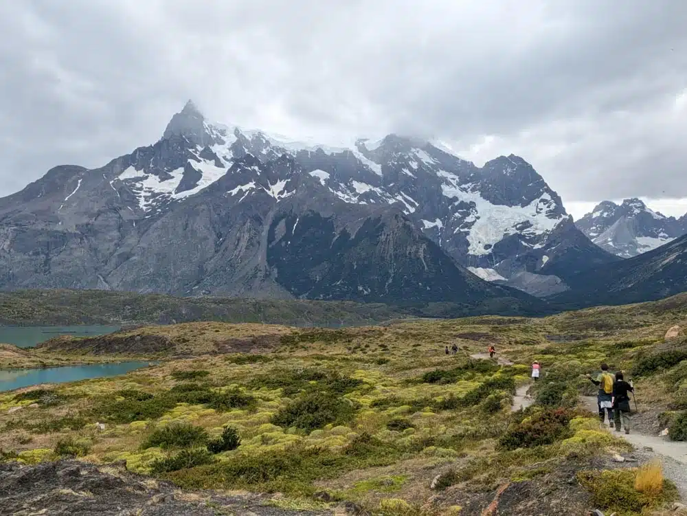 People walking along a trail with a mountain in the background in Torres Del Paine National Park