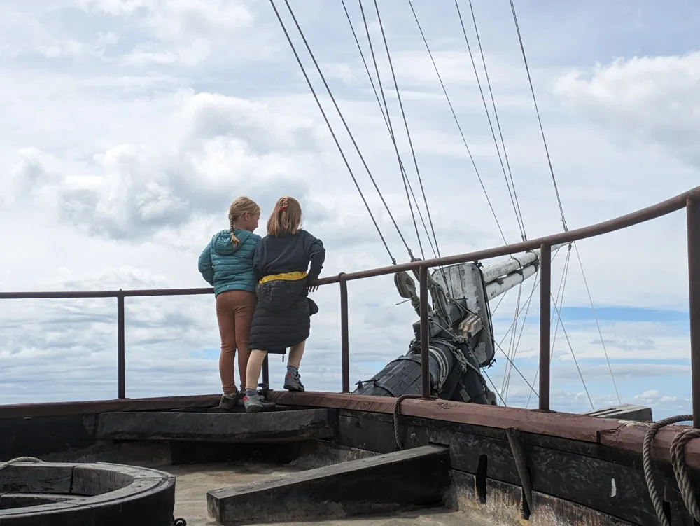 Girls standing at the front deck on the replica HMS Beagle looking out to sea  at Museo Nao Victoria in Punta Arenas