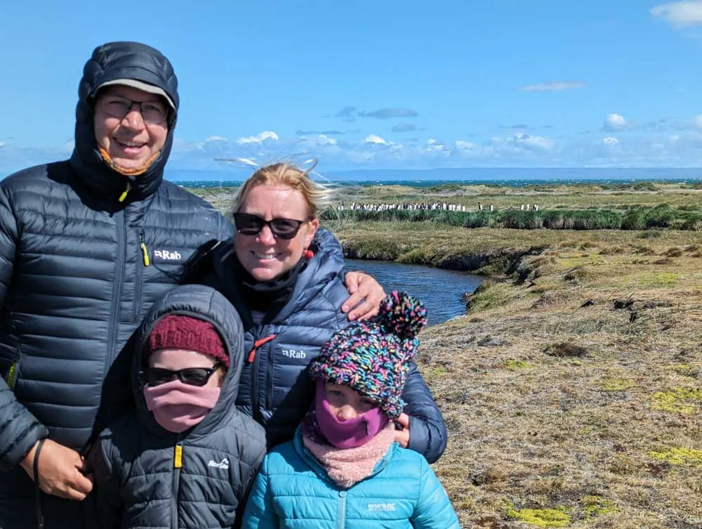 A family photo at Parque Pingüino Rey with a small colony of king penguins in the background