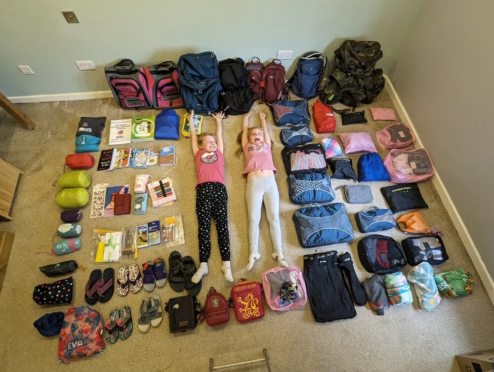 The essential packing list for isiting the Galapagos Islands with kids. Complete with Georgia and Eva lying stretched out on the floor in the middle of all our equipment.